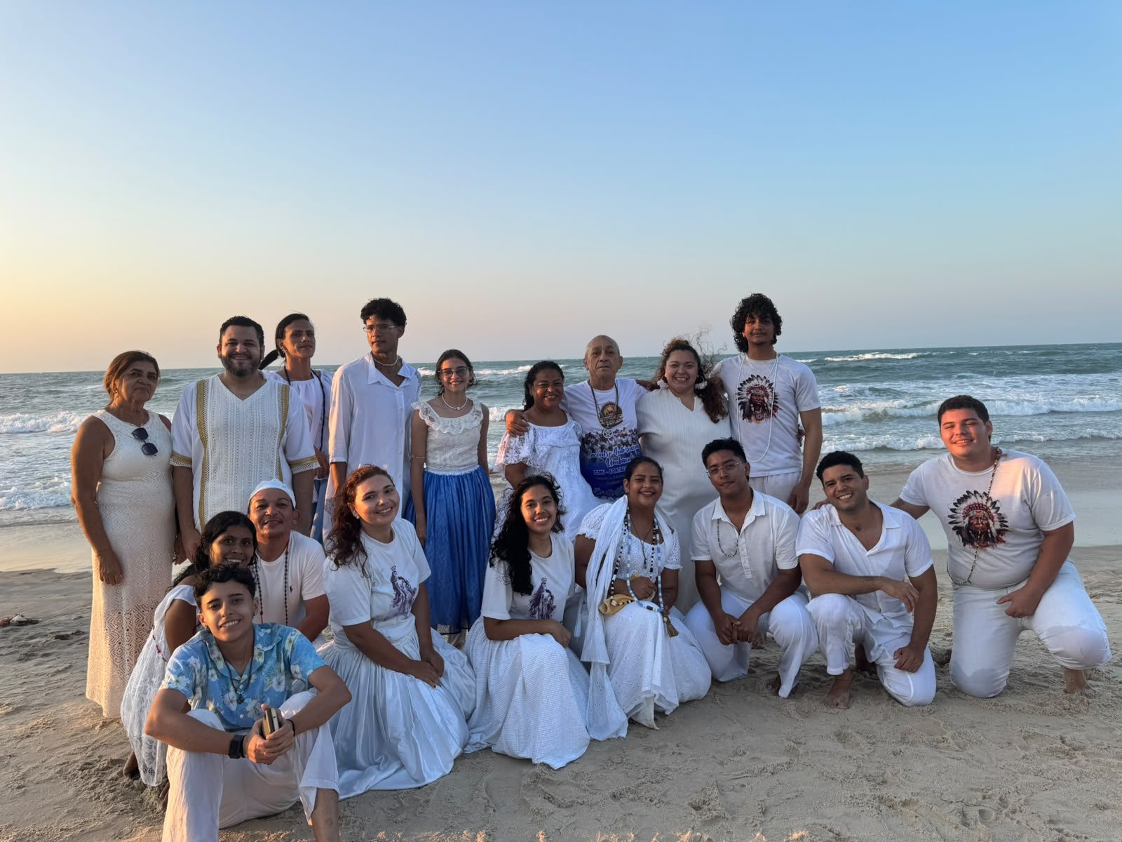 Coletivo D Terreiro reunido na praia durante caminhada corpo a corpo